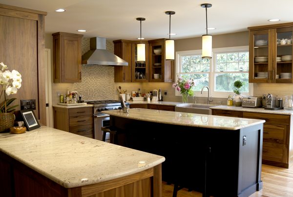 Wood cabinetry and a stone-topped two-tier island in a NOR custom kitchen remodel