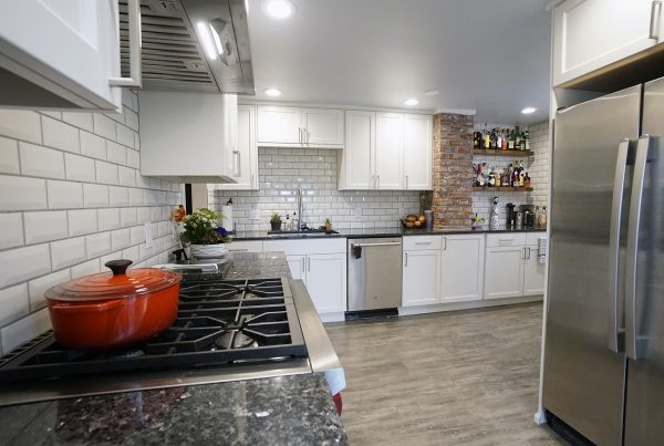 White shaker cabinetry, subway tile and a stone-topped peninsula in a West Seattle kitchen remodel
