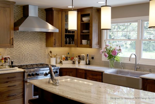 Walnut cabinets, mosaic tile backsplash, stainless hood and farmhouse sink in a Bridle Trails, Bellevue kitchen