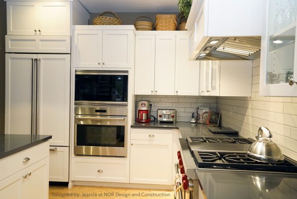 White shaker kitchen with paneled refrigerator, double wall ovens, subway tile and gas cooktop in an Issaquah remodel