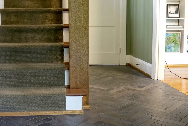 Staircase and entry with dark herringbone tile flooring in a Ravenna, Seattle home remodel