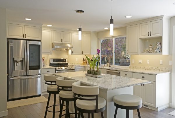Quartz island with counter stools, pendant lights and stainless appliances in a Seattle kitchen remodel