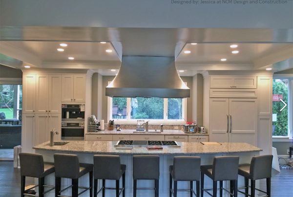 Large kitchen island with seating for eight, a stainless island hood and white cabinetry in a Seattle home remodel