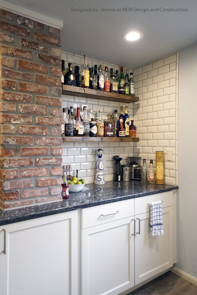 Floating wood bar shelves beside an exposed brick column over white cabinets in a West Seattle kitchen