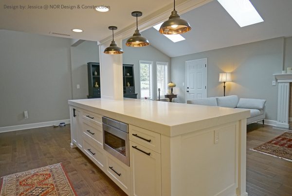 White kitchen island with a microwave drawer under a vaulted ceiling with skylights in a Woodinville remodel