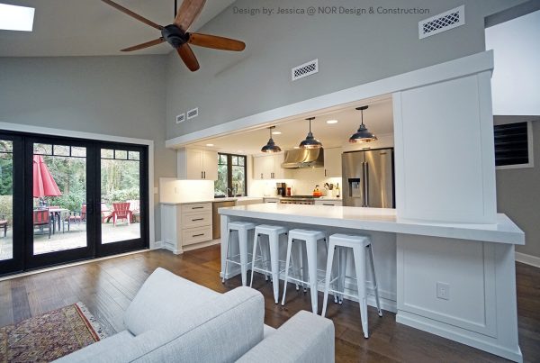 Open kitchen and family room with a quartz peninsula and French doors to the patio in a Woodinville remodel