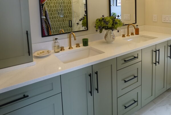 Sage green double vanity with brass faucets, white quartz and black mirrors in a Seattle bathroom remodel