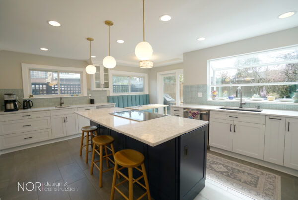 White kitchen with a navy island, globe pendants and a picture window in a Seattle kitchen remodel