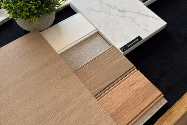 Quartz, tile and wood finish samples laid out for a kitchen remodel selection meeting