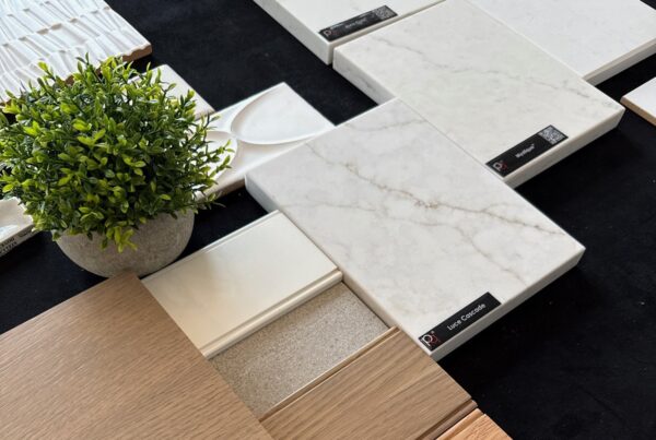 Quartz, tile and wood finish samples laid out for a kitchen remodel selection meeting