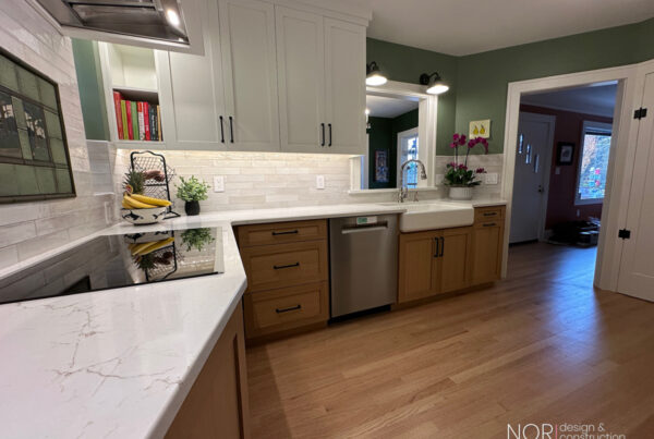 West Seattle kitchen remodel with wood lower cabinets, white tile backsplash, and a doorway opening to the adjoining room
